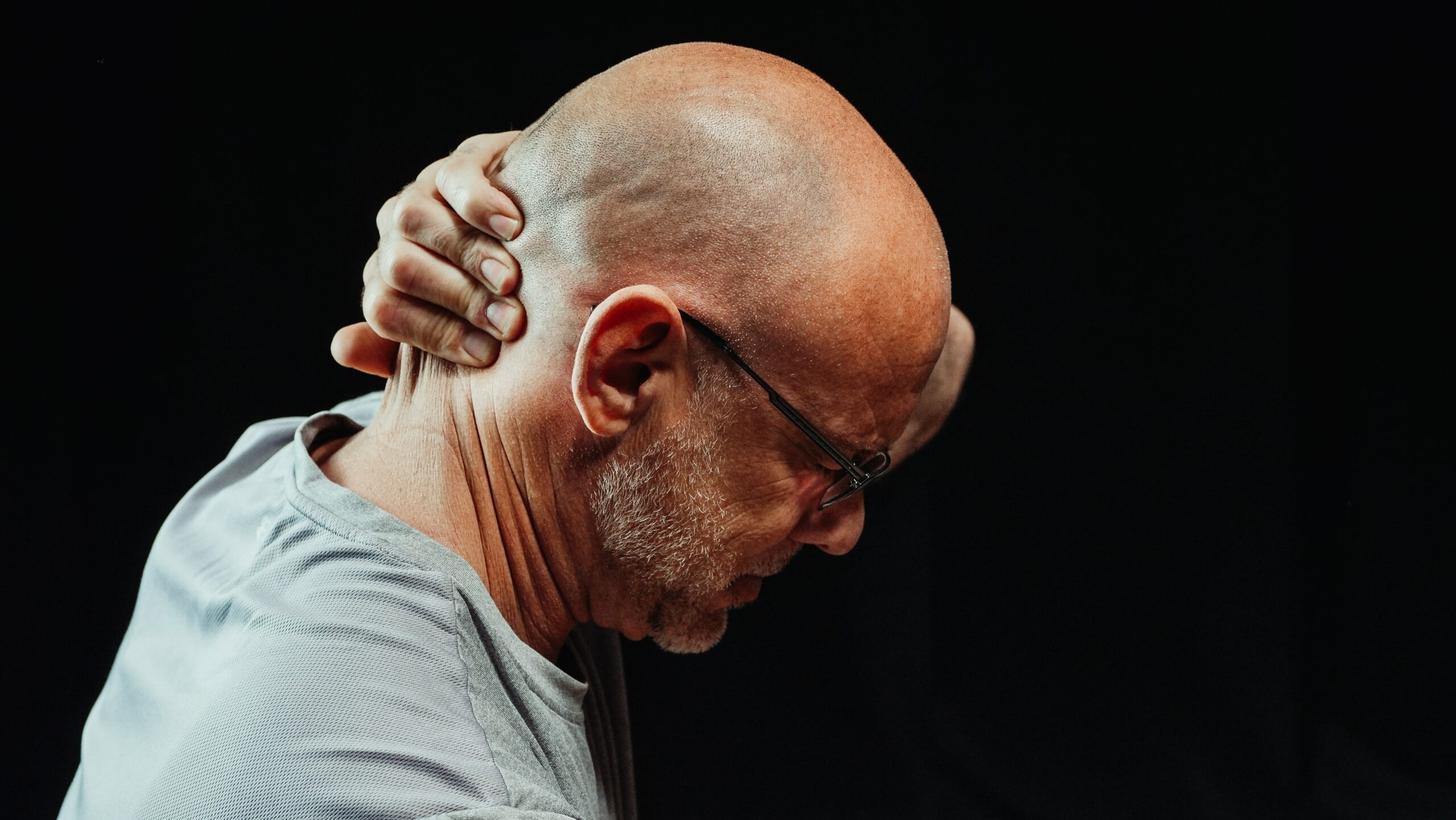Man holding back of head in pain
