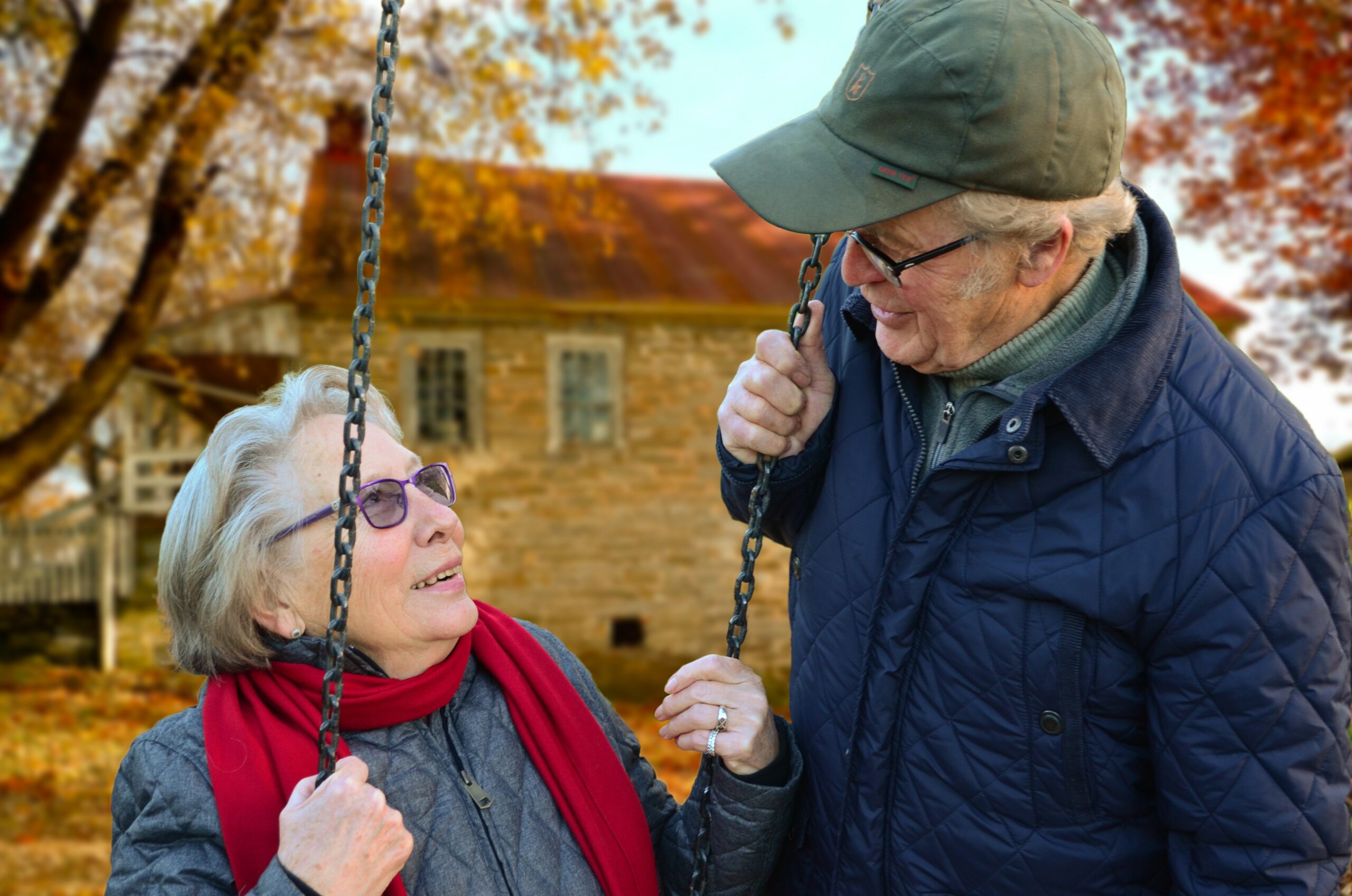 Older man with wife on a swing smiling together