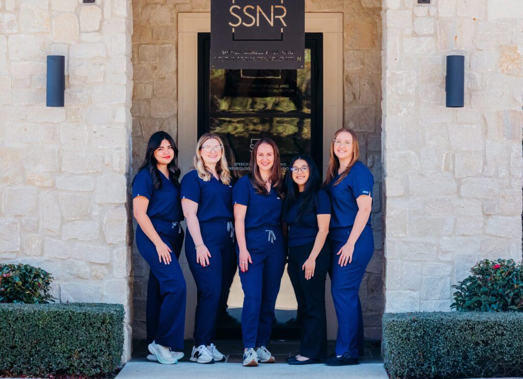 women in blue scrubs posing for team picture outside of SSNR