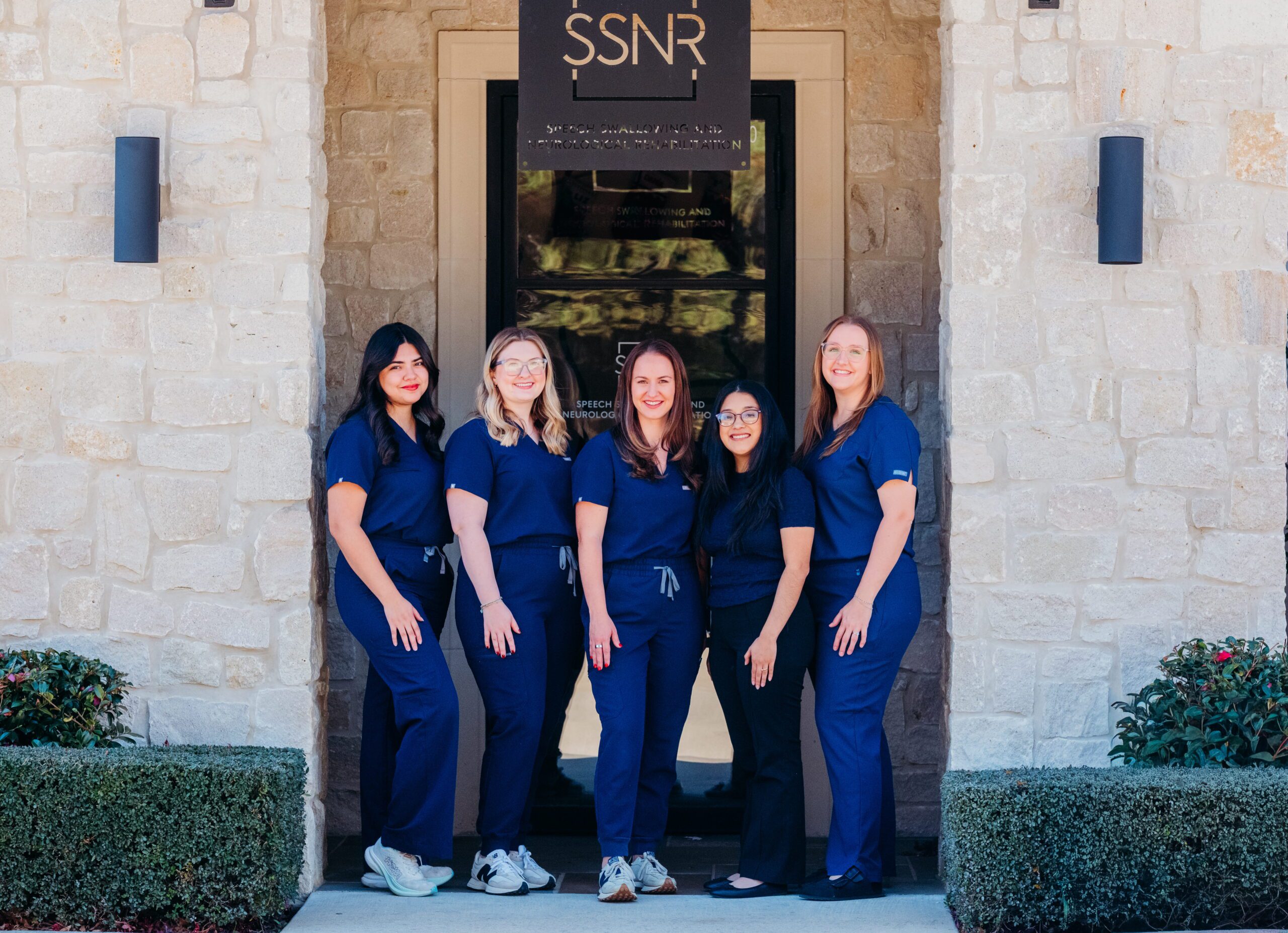 women in blue scrubs posing for team picture outside of SSNR