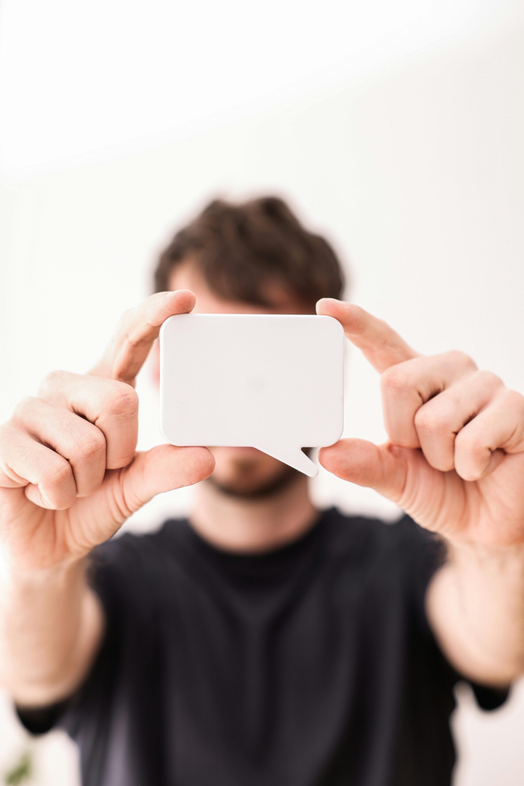 adult male holding a speech bubble