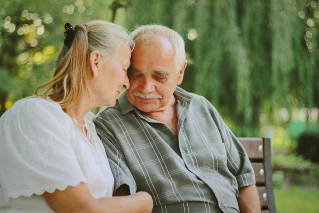 man and woman holding each other on a bench outdoors